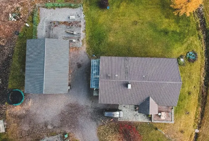 Vista aérea cenital de una vivienda rural y un anexo, probablemente en la provincia de Málaga, mostrando la cubierta y el estado general de los tejados. La imagen destaca la posibilidad de realizar inspecciones de tejados con drones, detectando posibles daños o necesidades de mantenimiento sin la necesidad de andamios. Ideal para propietarios, administradores de fincas y comunidades de vecinos en Málaga que busquen un servicio de inspección rápida y segura.