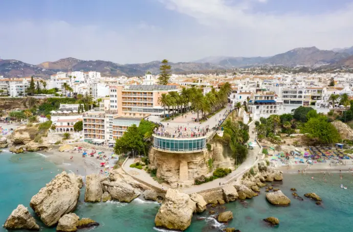 Esta espectacular vista aérea, capturada con nuestros drones en Nerja, te sumerge en la belleza de la "Perla de la Costa del Sol", destacando el icónico Balcón de Europa, sus playas cristalinas y el vibrante paisaje urbano que se extiende hacia las montañas. Ideal para promocionar destinos turísticos, propiedades con encanto o eventos en la costa de Málaga, esta imagen demuestra nuestra habilidad para obtener tomas aéreas de alta calidad que realzan la belleza y el atractivo de cualquier enclave. En Skymotion, ofrecemos soluciones de fotografía y video con drones que cautivan y conectan con tu audiencia en Nerja y toda la provincia de Málaga.